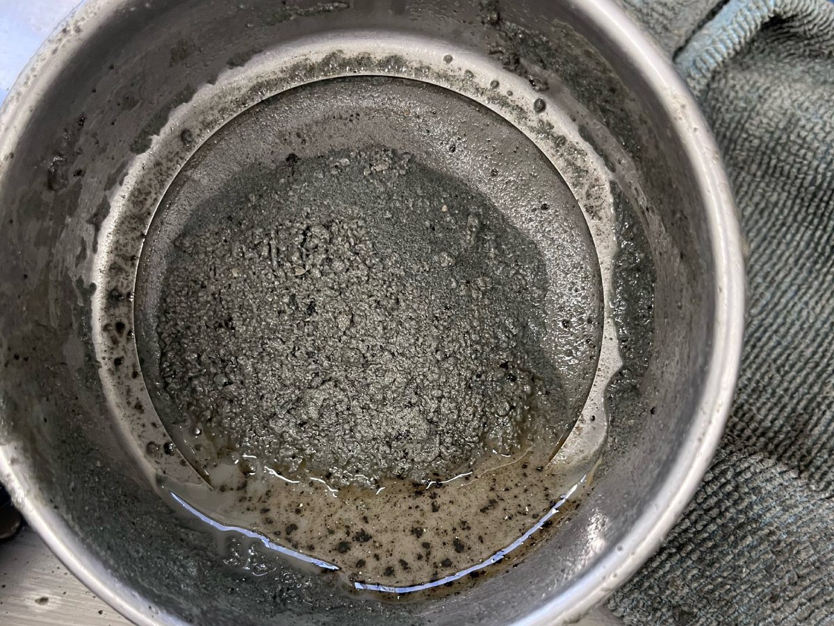 A dirty pot sitting on top of the floor.
