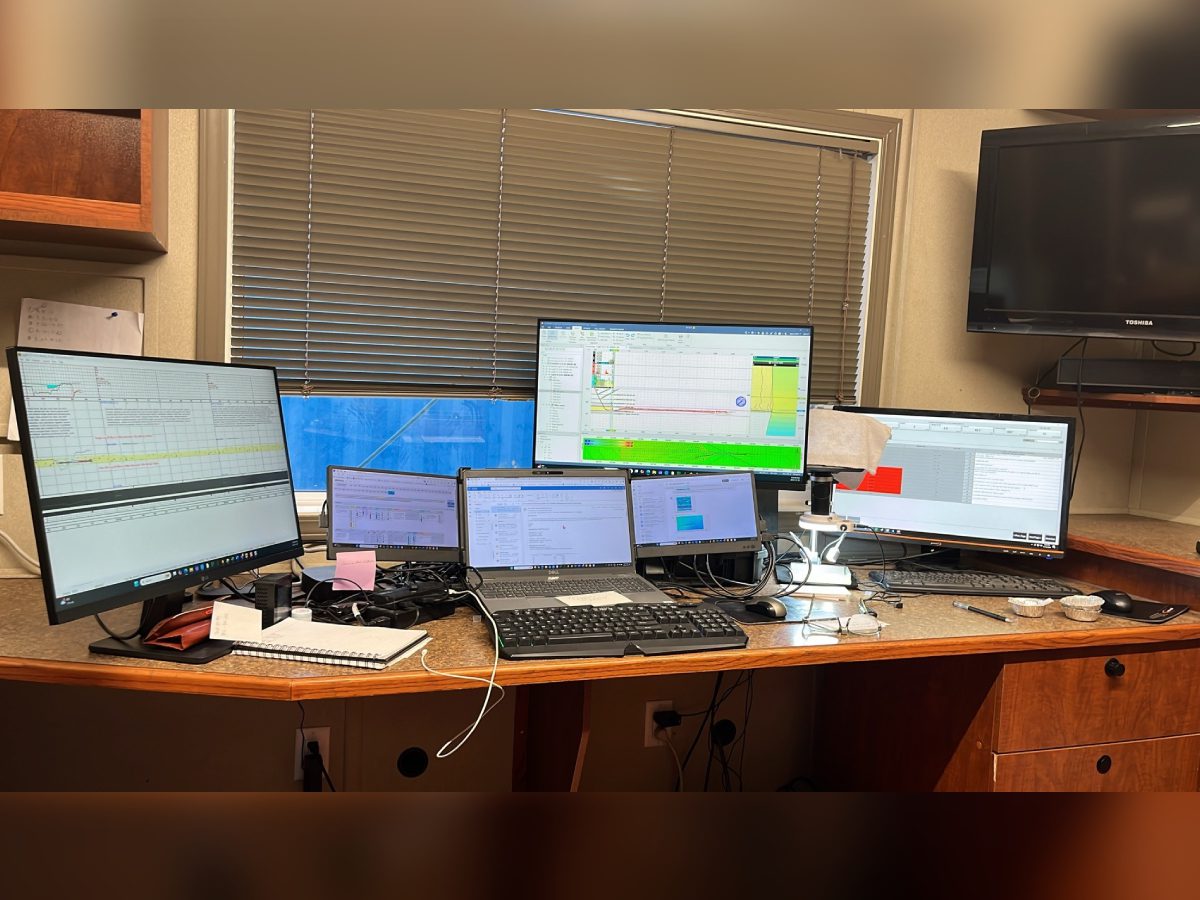 A desk with several laptops and monitors on it.